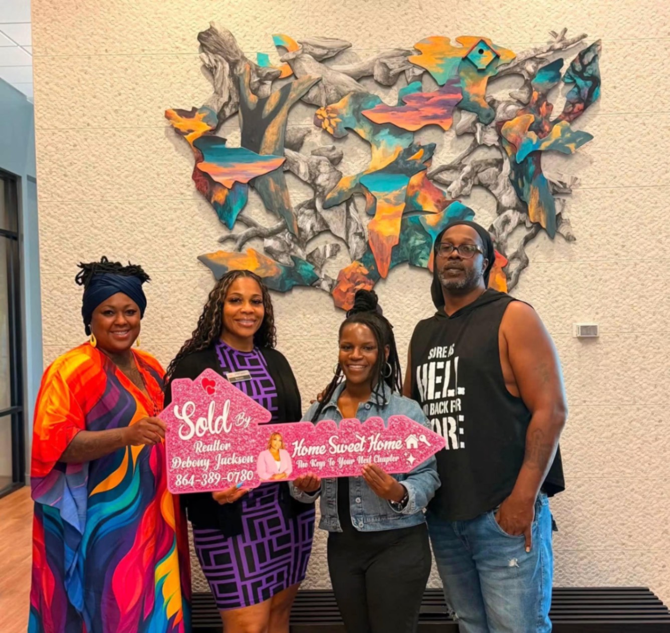 Clients celebrating their closing with Debony Jackson and the Sold sign